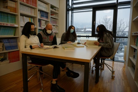 Alunni che studiano in biblioteca indossando le mascherine