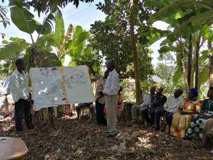 Eine Naturschutzgruppe stellt ihren Fünfjahresplan für den geschützten Wald an beiden Seiten der Grenze zwischen Uganda und Tansania vor. (Foto: Landesamt für Freiwilligenwesen und Solidarität)