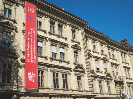 Il banner dedicato agli 80 anni dell’Accordo di Parigi apposto sulla facciata di Palazzo Widmann, sede della Giunta provinciale altoatesina. (Foto: Fabio Brucculeri)