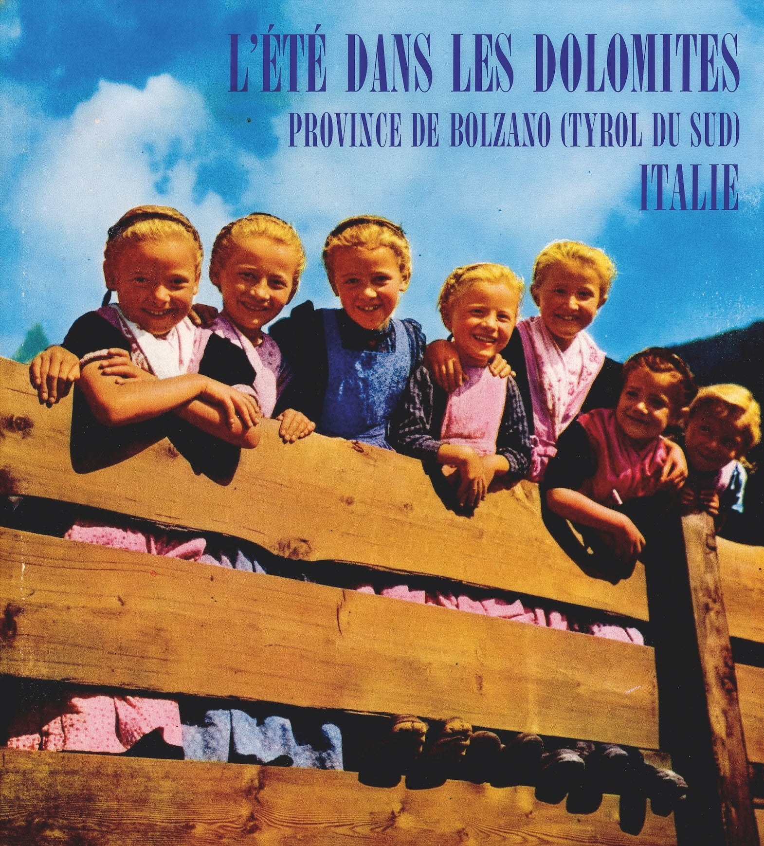 In den 1970er Jahren wurde Südtirol touristisch als idyllische Heimat für die Gäste inszeniert – mit traditionellen Motiven wie Bergen, Obstgärten, Bauernhäusern und Trachten. Im Bild „Eingeborene“ in Tracht, Prospekte und Plakate vermitteln ein traditionsbetontes Südtirolbild. (Foto: Touriseum)