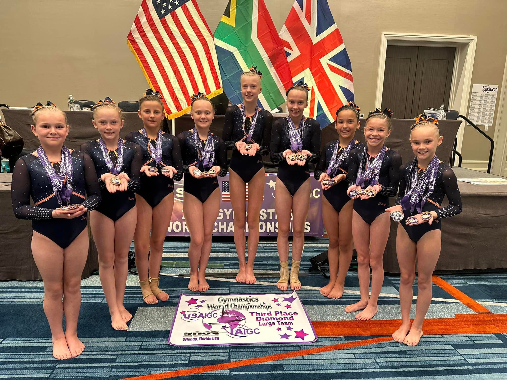 Young gymnasts posing with medals at the Gymnastics World Championships