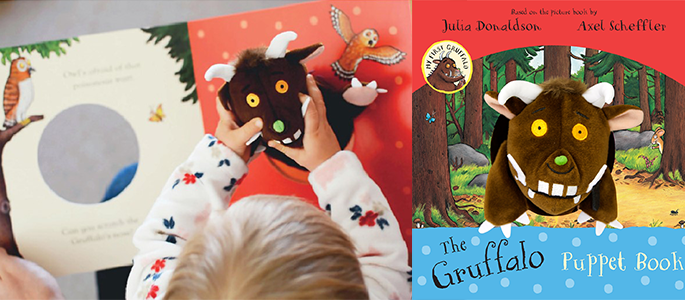 A young child playing with The Gruffalo puppet book.