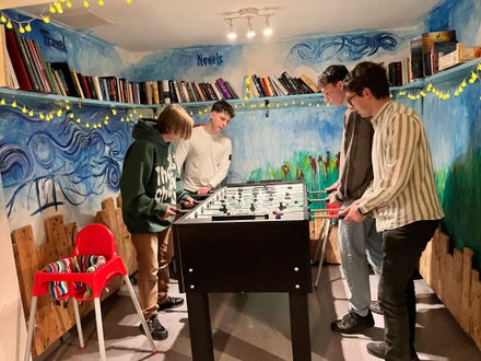 Momento di relax per gli studenti della Scuola Alberghiera Cesare Ritz di Merano in una sala ricreativa con biliardino e libreria, un ambiente stimolante per la crescita personale.