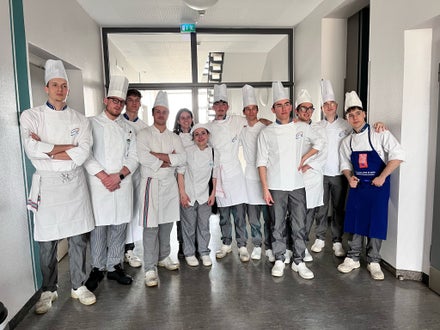 Studenti della Scuola Alberghiera Cesare Ritz di Merano in divisa da cuoco. Formazione pratica di eccellenza per futuri chef e professionisti della ristorazione.