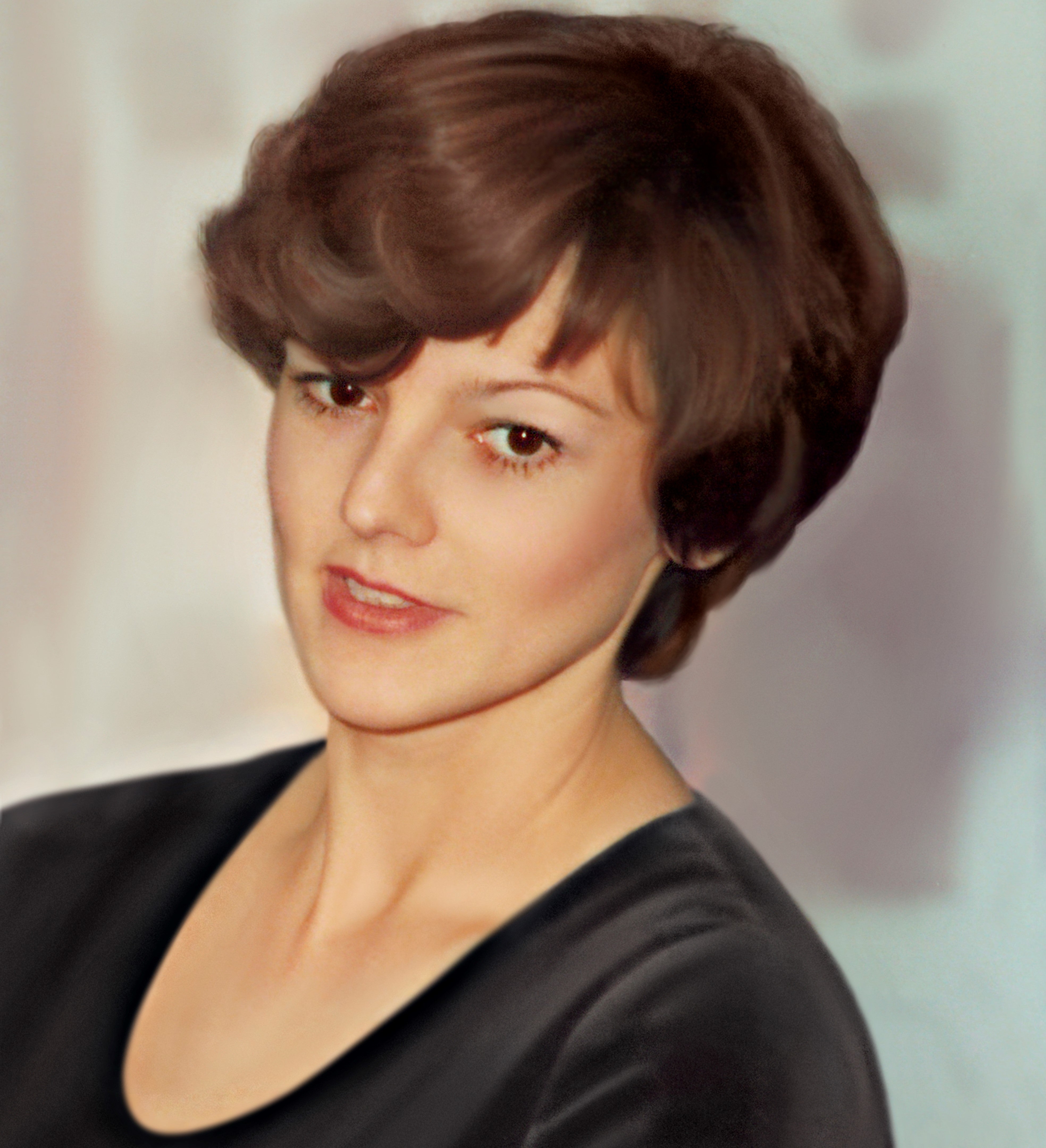 A portrait of Mechtild Harf with short brown hair and a calm expression, wearing a dark top. The background is softly blurred, putting focus on her face. The image has a timeless, classic feel.