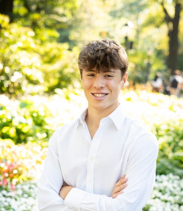 The patient Max is wearing a white shirt and smiling gently. A green forest can be seen in the background.