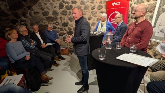 Il segretario generale dell'Euregio Christoph von Ach (in piedi, al centro della foto) ha fatto riferimento all'Anno dei musei dell'Euregio 2025, che con il motto “Guardare oltre” guarda al tempo di Gaismair e ben oltre. (Foto: Euregio/Armin Gluderer)