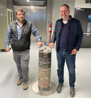 Landesrat Massimo Bessone mit Volkmar Mair, Direktor des Amtes für Geologie und Baustoffprüfung mit einem Zylinder voller Baustoffe für Straßenbau. (Foto: LPA) 