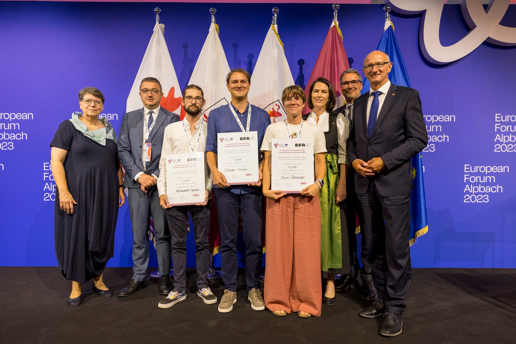 Die Siegerinnen und Sieger des Euregio-JungforscherInnen-Preis: (mit Diplomen v.l.) Alessandro Sartori (3. Platz), Donato Scrinzi (1. Platz), Laura Battistel (2. Platz) gemeinsam mit (weiters v.l.) Ulrike Tappeiner (Juryvorsitzende und Präsidentin der Freien Universität Bozen), LH Fugatti, Barbara Thaler (Vizepräsidentin Wirtschaftskammer Tirol und Europaparlamentarierin), LH Kompatscher und LH Mattle (Foto: Land Tirol/Sedlak)  