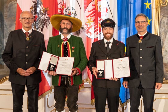 Hanno ricevuto la medaglia di salvataggio per aver estratto un uomo da un'auto in fiamme: Markus Wieland (Laion) e Daniel Bernardi (Selva) con i governatori Mattle (a sinistra) e Kompatscher (a destra). (Foto: Land Tirol/die Fotografen)