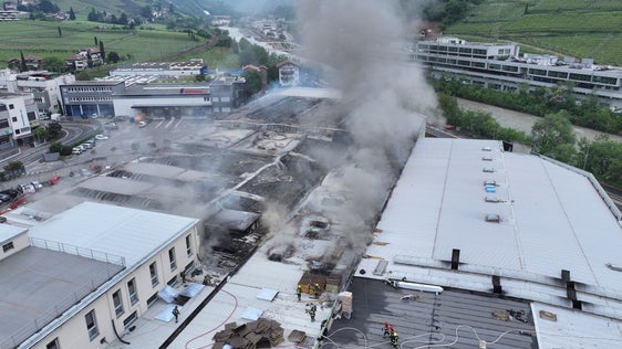 Die Berufsfeuerwehr analyisiert Usache und Dimensionen der Ausbreitung des Brandes am Sitz der Alpitronic am Mitterweg am Bozner Bozen, auch mit Hilfe von Drohnenaufnahmen; das Bild zeigt die Lage heute gegen Mittag. (Foto: LPA/Berufsfeuerwehr)