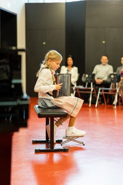 Marie Gruber aus der Musikschule Lana bei ihrem Wertungsauftritt in Landeck: Sie war eine von insgesamt 75 Teilnehmenden, die in der Wertungskategorie Steirische Harmonika angetreten sind. (Foto: LPA/Shakesbear Photography & Art)
 
