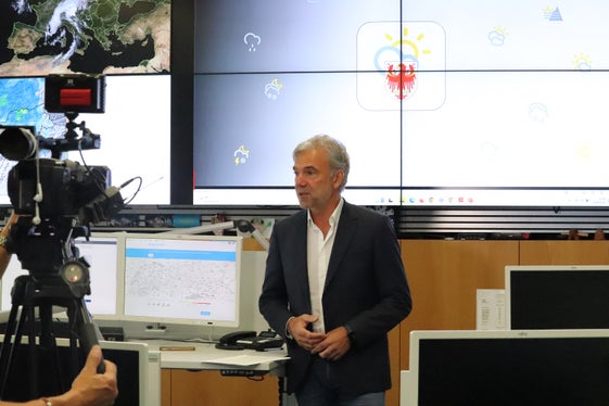 Die Südtirol-Wetter-App hat sich längst als Alltags- und Freizeitbegleiter etabliert: Landesrat Schuler vor den Bildschirmen mit den Wetterdaten und dem Logo der App. (Foto: LPA/Maja Clara)