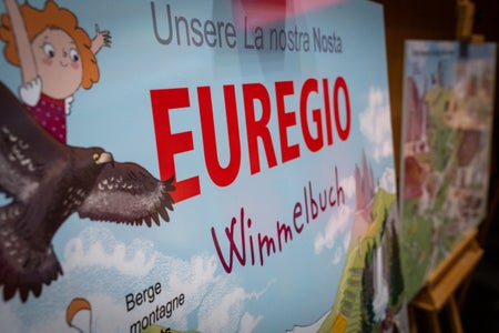 Auf Schautafeln wurde das Wimmelbuch während der Sitzung der Euregio-Versammlung vorgestellt. (Foto: Land Tirol/Neuner)