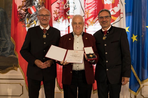 Mit der Verdienstkreuz des Landes Tirol von den Landeshauptleuten Anton Mattle (links) und Arno Kompatscher (rechts) ausgezeichnet: Norbert Bertignoll (Mitte) aus Neumarkt. (Foto: Land Tirol/Sedlak)