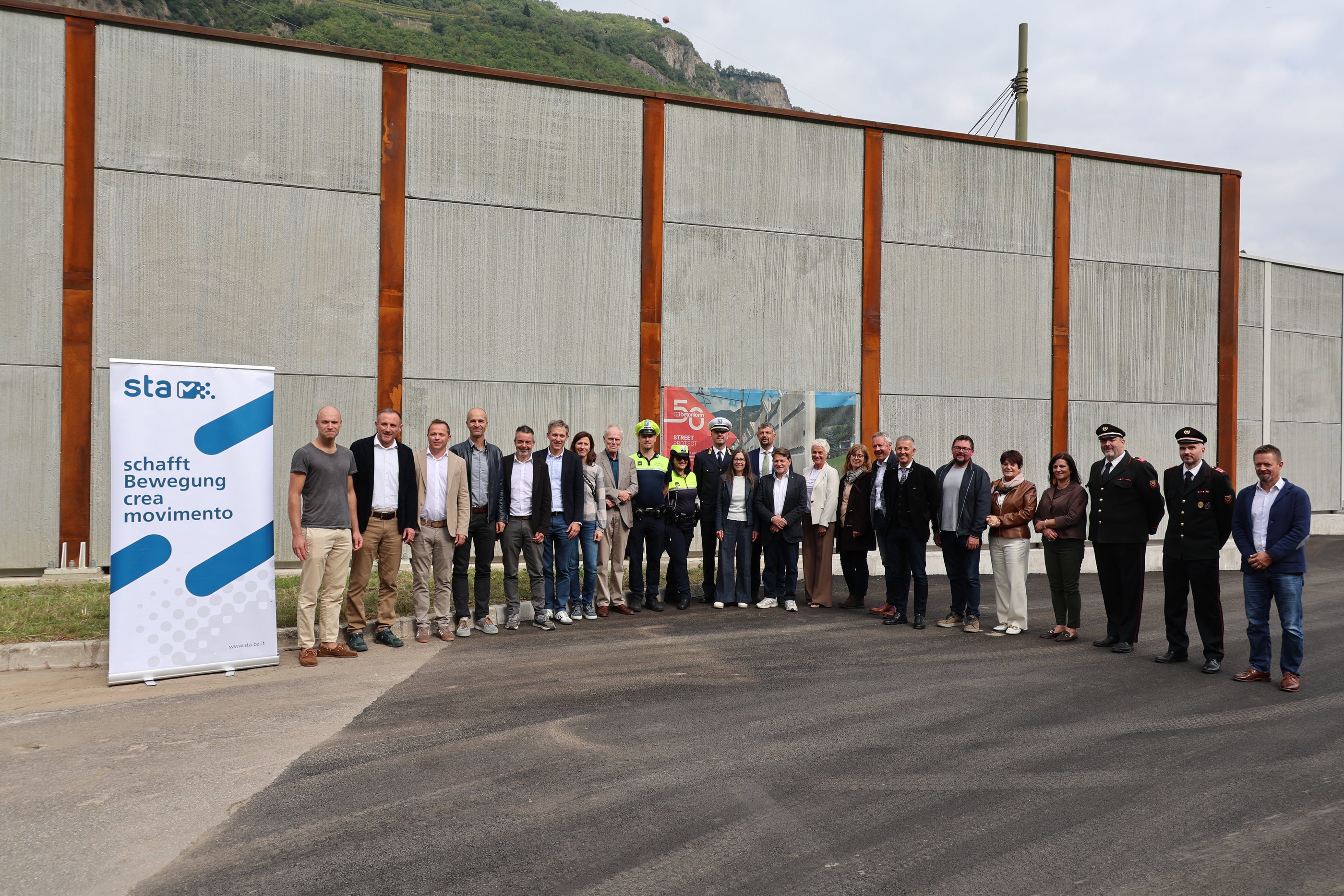 Die Fertigstellung der Lärmschutzwand in Blumau wurde am 29. September gemeinsam mit der Bevölkerung gefeiert. Im Bild mit Vertretern der beteiligten Institutionen und Unternehmen: Landesrat Daniel Alfreider (12. von rechts), Landesrat Peter Brunner (7. von rechts) und Karneids Bürgermeister Albin Kofler (8. von rechts). (Foto: LPA/Ingo Dejaco)