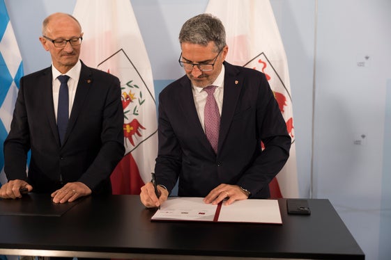 Il presidente Kompatscher firma la dichiarazione d'intenti comune, a sinistra il presidente del Tirolo Mattle (Foto: Land Tirol/Sedlak)