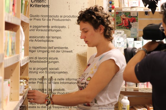 Bewusstsein für Herkunft der Produkte und Lebensumstände der Produzenten: Sophie Baumgartner wird ihren freiwilligen Zivildienst im Weltladen Bozen bis Herbst fortsetzen; im Hintergrund die Kriterien der Weltläden. (Foto: LPA/Maja Clara)