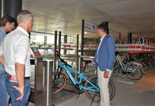 Sicher abgestellt werden können Fahrräder im Mobilitätszentrum Brixen nicht nur in Einzelboxen, sondern auch im Sammeldepot wo es Platz für besonderes viele Fahrräder gibt (im Bild v.l.: Xausa, Brunner und Alfreider beim Einchecken des Rads). (Foto: LPA/Angelika Schrott)
