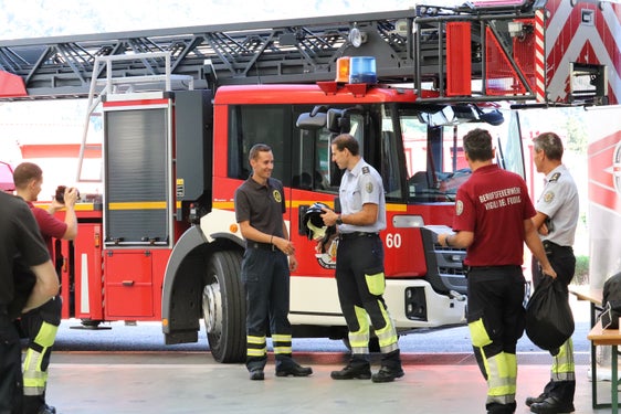 "Guten Kurs!" hat Kursdirektor Brandinspektor Felix Reggiani (Bildmitte) gewünscht und allen Teilnehmenden einen Feuerwehrhelm überreicht. (Foto: LPA/Maja Clara)