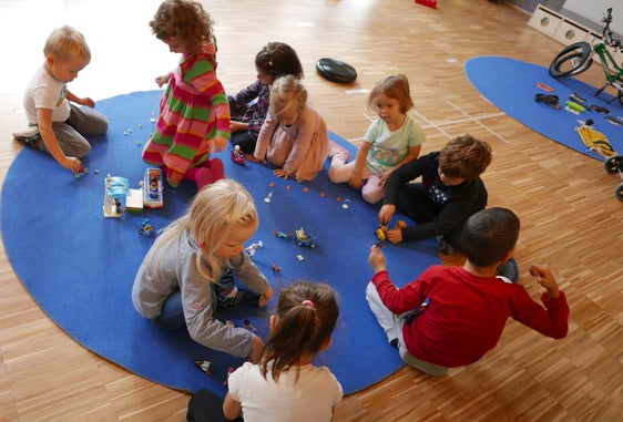 Spielerisch nachhaltige Mobilität üben: Gleich nach der Vorstellung des Mobilitätskoffers im Kindergarten St. Johann in Bozen werden die Inahlte von den Kindergartenkindern in Beschlag genommen. (Foto: STA/Elisa Zambiasi)