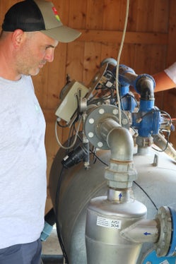 Eine sensorbasierte Bewässerung nutzt Bodenfeuchtedaten, um die Wasserzufuhr für Pflanzen vollautomatisch zu steuern: Sensoren messen im Wurzelbereich die aktuelle Feuchtigkeit oder Saugspannung, und Bewässerungsanlagen geben daraufhin nur dann Wasser ab, wenn es die Pflanzen tatsächlich benötigen. Im Bild Bereichsleiter Stephan Raffl neben dem Quarzsandfilter. (Foto: LPA/Maja Clara)