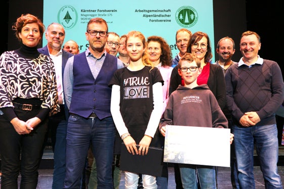 Unser Holz für unsere Kinder erreichte Platz 2 in seiner Kategorie. Im Bildvordergrund zwei  Schüler, mit ihm Bild einige Projektbegleiter: (von links) Direktorin Ulrike Mair, Martin Rienzner, Bürgermeister von Toblach, Michael Hofmann, Direktor des Forstinspektorates Welsberg und Günther Pörnbacher, Franz Troger, Christian Stabinger, Barbara Rossi, Josef Gruber, Astrid Stolzlechner, Martin Bachmann und Stefan  Obersteiner. (Foto: Chris Thomas)
