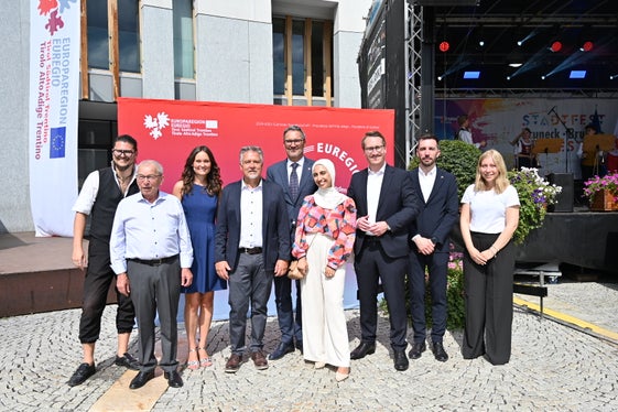 In piedi al dialogo sull'Euregio (da sinistra) Simon Mariacher, Josef Urthaler, la moderatrice Nicole Abler, il sindaco Bruno Wolf, il presidente dell'Euregio Arno Kompatscher (Alto Adige), Assia Brahimi, il vicepresidente Philip Wohlgemuth (Tirolo), l'assessore provinciale Simone Marchiori (Trentino), Celina Moser. (Foto: Associazione Brunico Plan de&nbsp;Corones Turismo/Gianvito Coco)