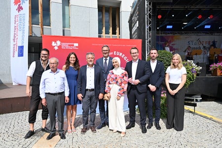 Standen im Euregio-Dialog (v. l.) Simon Mariacher, Josef Urthaler, Moderatorin Nicole Abler, Bürgermeister Bruno Wolf, Euregio-Präsident Arno Kompatscher (Südtirol), Assia Brahimi, Landeshauptmannstellvertreter Philip Wohlgemuth (Tirol) , Landesrat Simone Marchiori (Trentino), Celina Moser. (Foto: Bruneck Kronplatz Tourismus/Gianvito Coco)