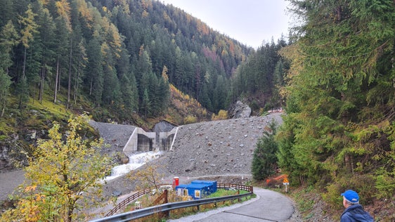 Die Wildbachverbauung hat im Öttenbach in Sarnthein die Sperre aus Stahlbeton um zwei auf nunmehr circa neun Meter erhöht und die Betonsichtfläche zum Teil mit Materialbewegungen und Auffüllungen verdeckt, um sie anschließend noch zu begrünen. (Foto: LPA/Landesam für Wildbach- und Lawinenverbauung Nord)