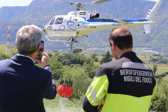 Landeshauptmann und Bevölkerungsschutzlandesrat Arno Kompatscher und Berufsfeuerwehroffizier und Kursleiter Felix Reggiani beobachten den Hubschrauber, der punktgenau Löschwasser aus dem Faltbecken entnommen hat. (Foto: LPA/Maja Clara)