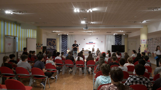 Ragazze e ragazzi durante l'evento tenutosi al Centro Giovanile Terraferma a Don Bosco: qui il saluto sul palco di Gabriele Guatteri, responsabile pedagogico. (Foto: TV33)