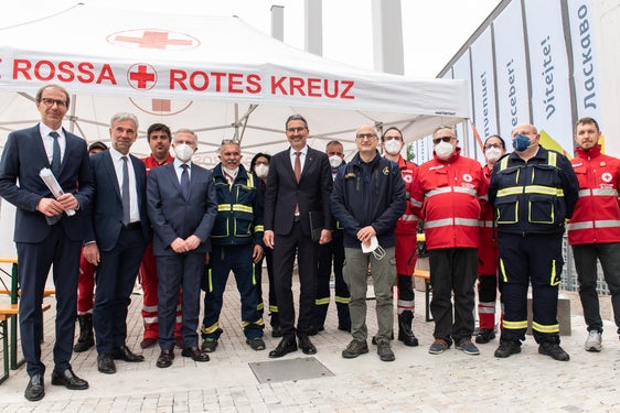 Davanti al centro di accoglienza (da sinistra): il direttore della protezione civile Unterweger, l'assessore Schuler, il commissario del governo Cusumano, il presidente della Provincia Kompatscher, il capo della protezione civile Curcio con i rappresentanti della Croce Bianca e della Croce Rossa (Foto: ASP/Ivo Corrà)