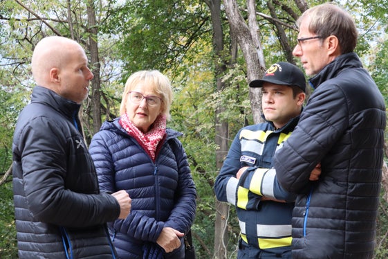 Beim Bauwerk, das den Hochwasserschutz für den Stadtteil Oberau-Haslach verstärkt (von links): der Direktor des Landesamtes für Wildbach- und Lawinenverbauung Süd Thomas Thaler, Stadtviertelrätin Judith Kofler Peintner, die beim Lokalaugenschein die Präsidentin des Stadtviertelrats vertrat, der stellvertretende Kommandant der Freiwilligen Feuerwehr Oberau-Haslach Damian Prenner, der Direktor der Agentur für Bevölkerungsschutz Klaus Unterweger. (Foto: LPA/Maja Clara)