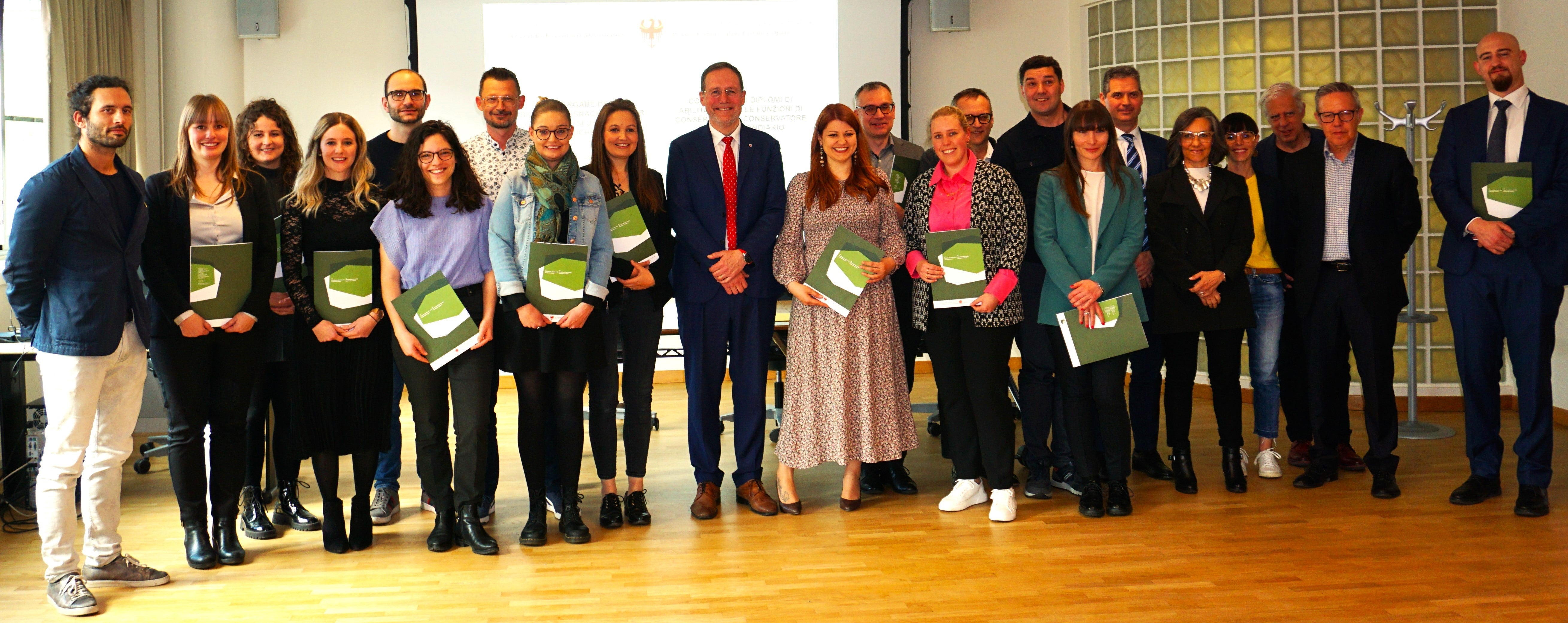 16 neue Grundbuchführerinnen und -führer haben den Qualifizierungslehrgang der Landesabteilung Grundbuch und Kataster erfolgreich abgeschlossen und ihre Diplome aus den Händen von Landesrat Massimo Bessone (Mitte) erhalten. (Foto: LPA)
