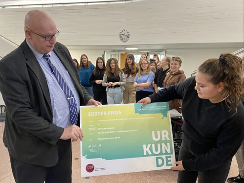 Wettbewerbsleiter Hans-Georg Lambertz bei der heutigen Prämierungsfeier in Tisens mit Eva Oberperfler und den Schülerinnen der Siegerklasse im Hintergrund (Foto: LPA/Fachschule Tisens)