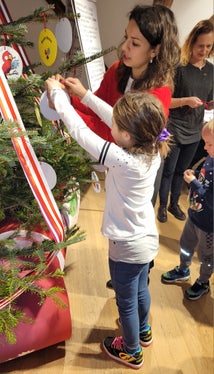 Mit der Hilfe von Valentina Stecchi haben die Kinder am Ende des Workshops auch den Christbaum mit ihren Werken geschmückt. (Foto: Euregio/Armin Gluderer)