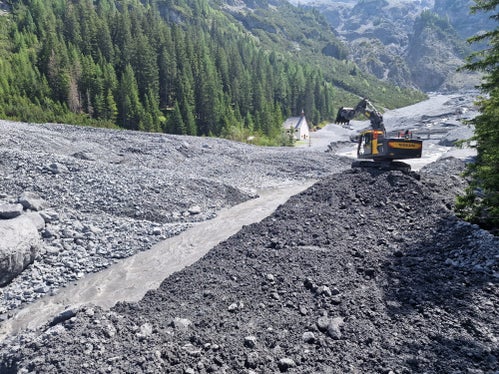 Die Wildbachverbauung hat nach dem Abgang einer Mure im Pleisserbach in Trafoi mit den Aufräumarbeiten begonnen; im Hintergrund links die Wallfahrtskirche zu den Heiligen drei Brunnen. (Foto: LPA/Amt für Wildbach- und Lawinenverbauung West in der Agentur für Bevölkerungsschutz)