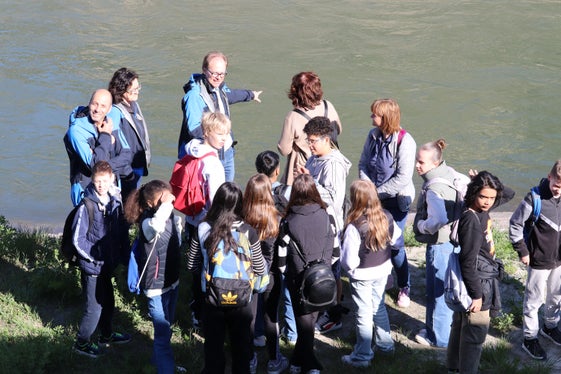 Qual è la portata odierna del fiume Adige?  I ragazzi della scuola media di Salorno con (da sinistra) Werner Verant e Doris Niederjaufner dell'Ufficio provinciale Protezione civile e Rudi Nadalet, dell'Ufficio provinciale Idrologia e dighe,  alla stazione di misurazione del livello dell'Adige di Salorno. (Foto: USP/Maja Clara)