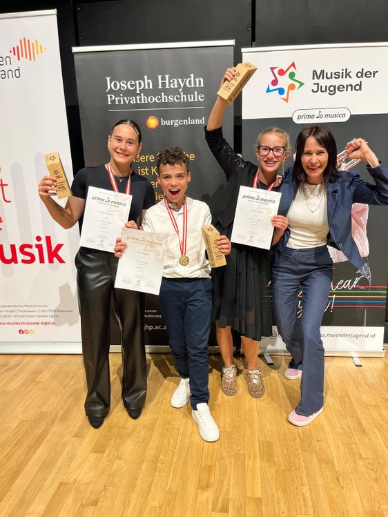 I suonatori di cetra (da sinistra) Marie Dorfmann della Scuola di musica di Chiusa/Siusi, Julius Nöckler e Julia Anna Stocker, entrambi della Scuola di musica di Brunico, festeggiano la vittoria a livello nazionale insieme alla loro insegnante Reinhilde Gamper. (Foto: USP/privata)