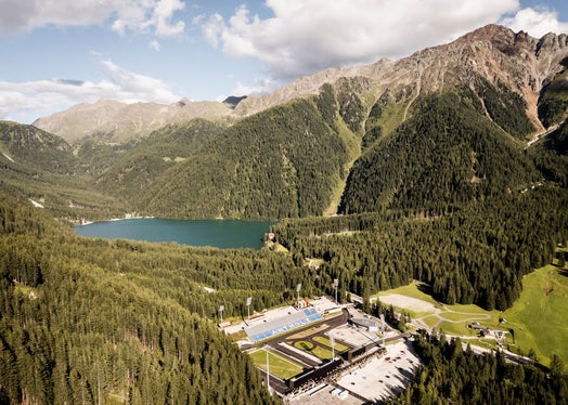 Una splendida immagine della Südtirol Arena Alto Adige, sede delle gare di biathlon ai Giochi Olimpici Invernali di Milano Cortina 2026. Anche all'interno del centro del biathlon è previsto il passaggio della fiaccola olimpica, con una cerimonia molto particolare all'interno dell'impianto di gara. (Foto: Hannes Niederkofler)