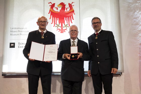 Il dottor Werner Wallnöfer (al centro) di Bolzano ha ricevuto con gioia il riconoscimento per i suoi meriti a favore della comunità ecclesiastica e civile, in particolare come presidente di lunga data del consiglio parrocchiale, dalle mani dei presidenti Anton Mattle (a sinistra) e Arno Kompatscher. (Foto: Land Tirol/Sedlak)