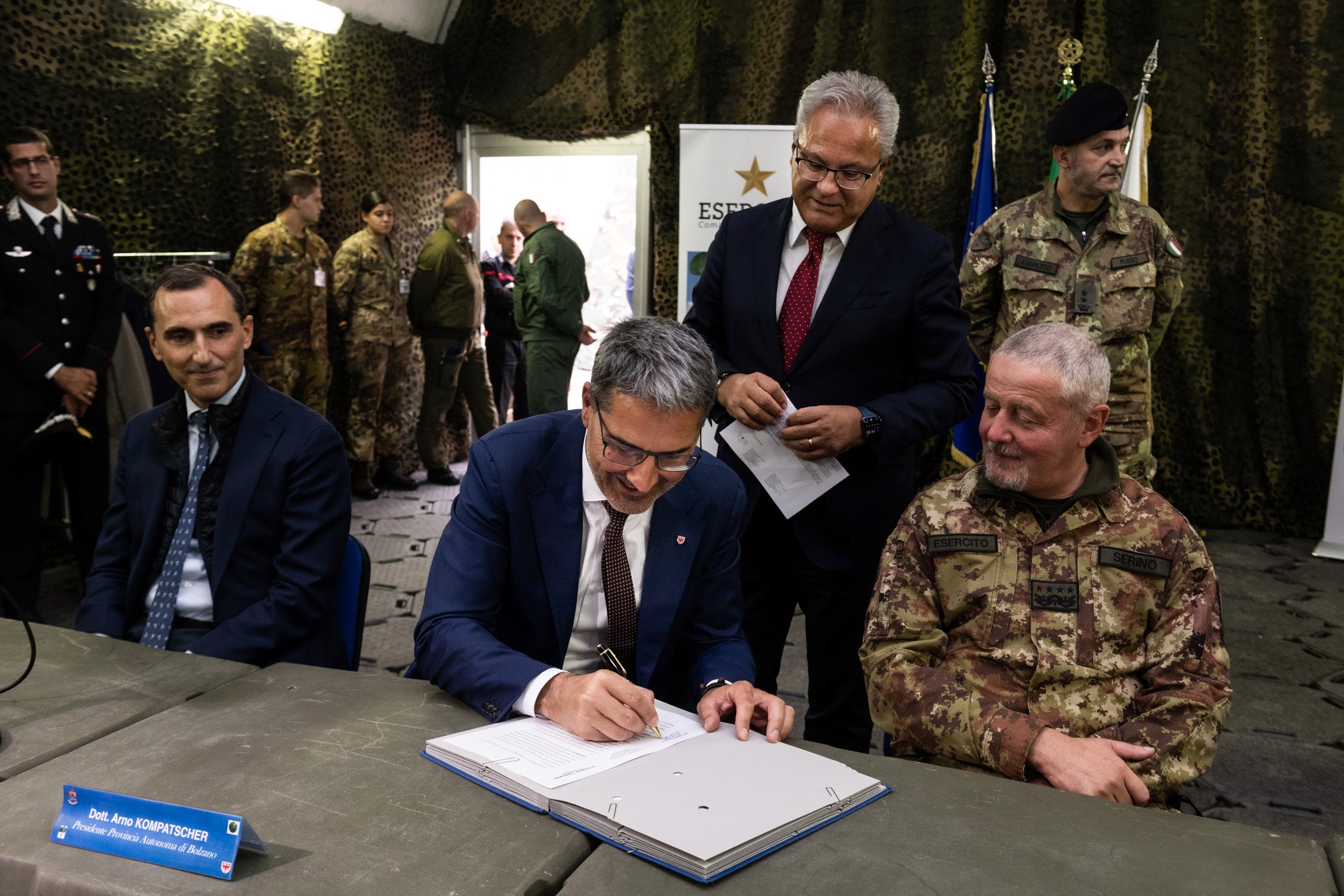 Landeshauptmann Kompatscher unterzeichnet das Übergabeabkommen, mit im Bild Staatsgüteragentur-Direktor Caizza (ganz links), Generalsekretär Magnago (im Hintergrund) und der Generalstabschef des Heeres, Serino (ganz rechts) (Foto: LPA/Ivo Corrà)