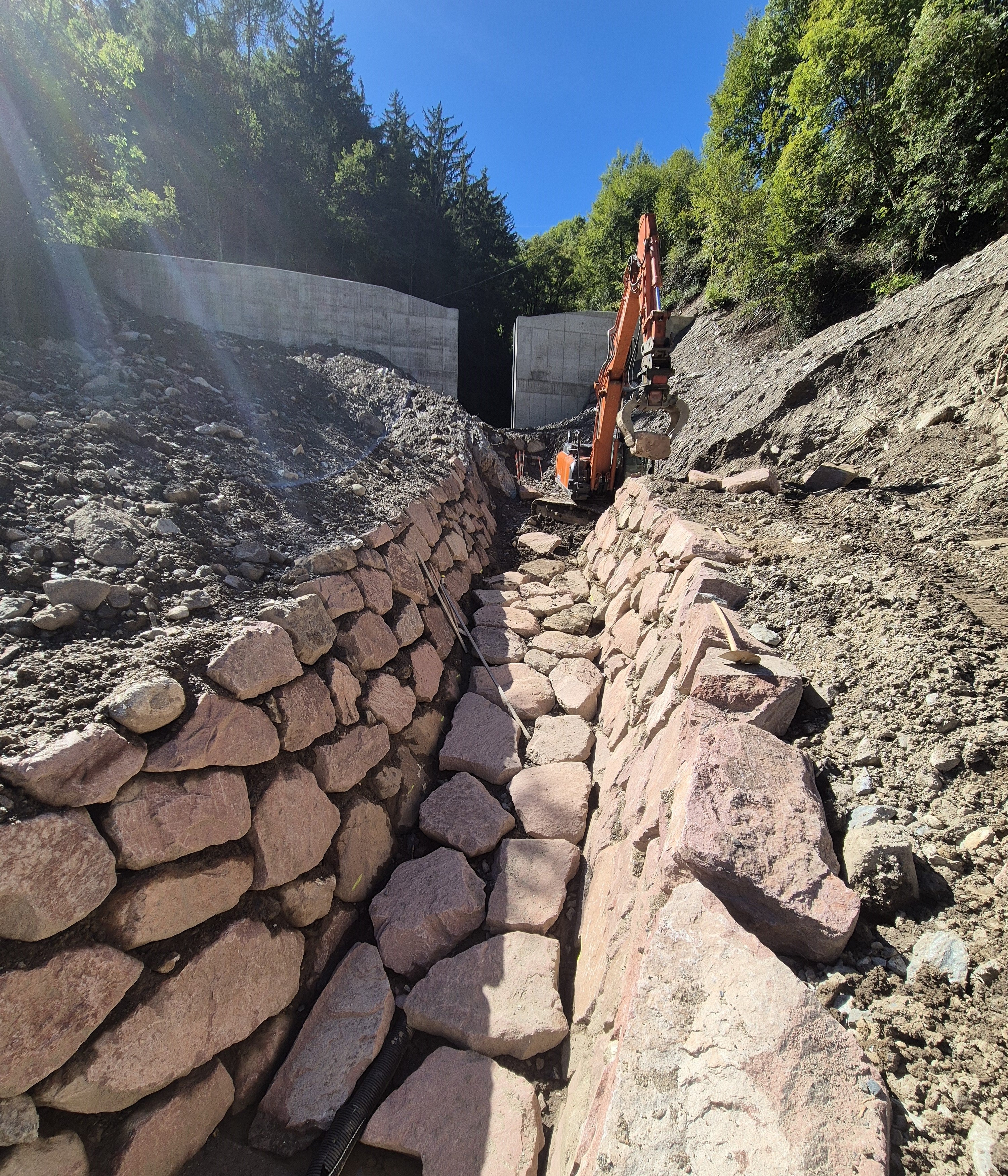 Zwischen März und September war die Wildbachverbauung im Schiedmanngraben südlich von Kollmann am Werk: Bergseits vom Schiedmannhof haben die Arbeiter eine 7 Meter hohe und 35 Meter breite Rückhaltesperre aus Stahlbeton errichtet und anschließend eine 30 Meter lange Künette (im Bild). (Foto: LPA/Landesamt für Wildbach- und Lawinenverbauung Nord in der Agentur für Bevölkerungsschutz/Johannes Holzner)