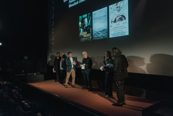 Preisverleihung des Dolomiten Unesco Welterbe Spezialpreises für Umberto Eco – La biblioteca del Mondo, ein kurzweiliger Dokumentarfilm mit Spielfilmelementen. Im Hintergrund die drei nominierten Filme.  (Foto: LPA/Daniele Fiorentino)