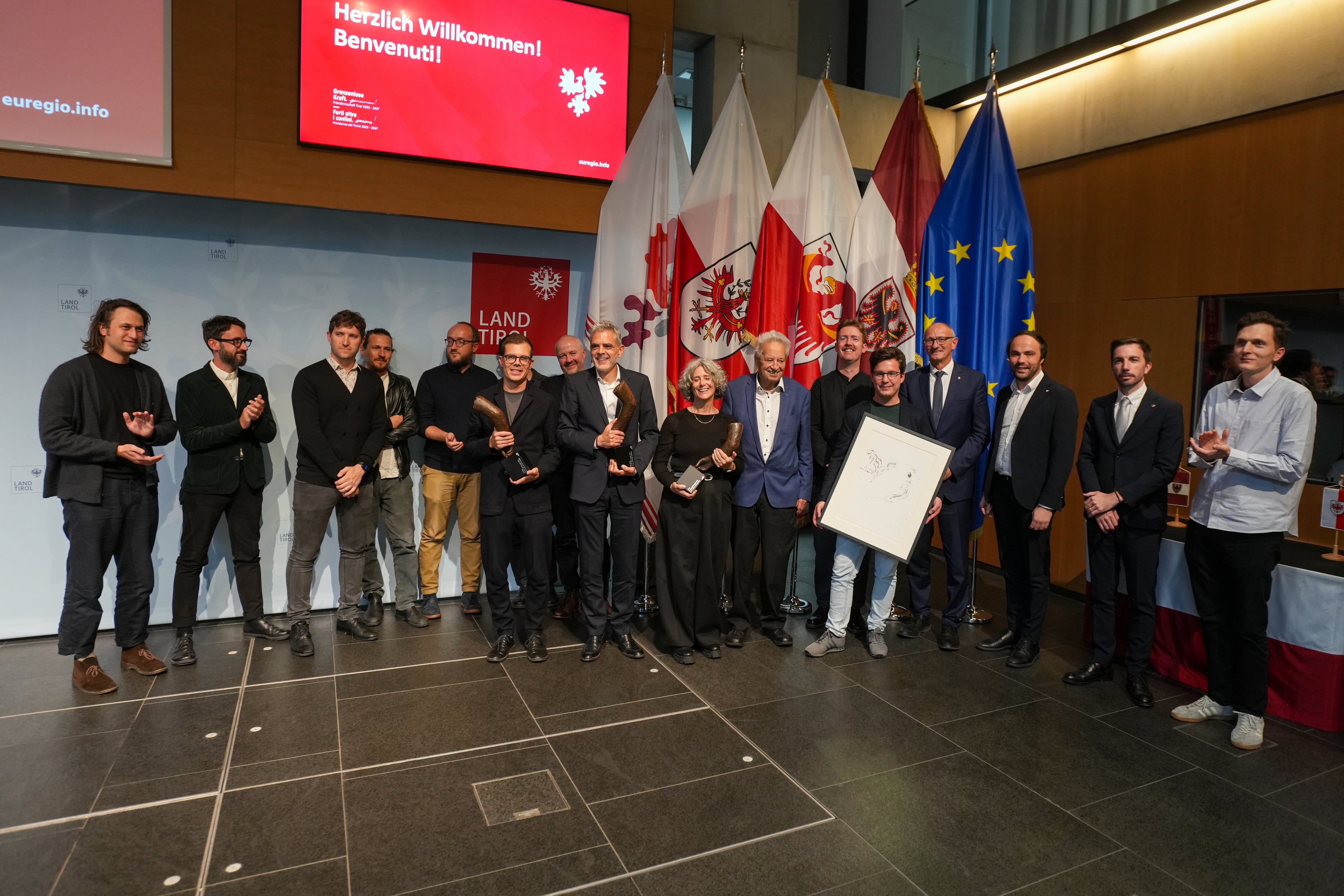 Euregio-Präsident, Landeshauptmann Anton Mattle, die Landesräte Philipp Achammer (Südtirol) und Simone Marchiori (Trentino), Landeshauptmann außer Dienst Wendelin Weingartner sowie Lois Anvidalfarei gratulieren den Preisträgern und Preisträgerinnen der Euregio-Baukulturpreise, Studio Lois, Lukas Mayr und Campomarzio sowie den Preisträgern des Publikumspreises „he und du“. (Foto: Land Tirol/Danijel Jovanovic)
