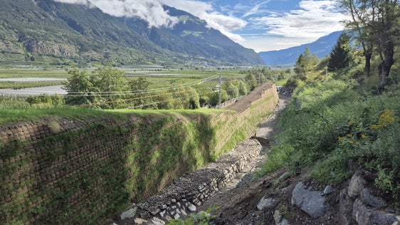 Im Bereich "Holzbrugg" entlang der Vinschger Bahnlinie bei Schlanders hat die Südtiroler Transportstrukturen AG (STA) einen neuen Schutzdamm fertiggestellt. (Foto: LPA/STA)