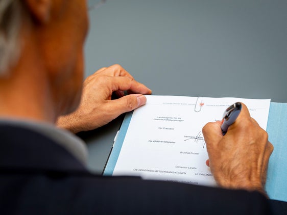 Hermann Troger firma la bozza di accordo in qualità di presidente dell'Agenzia provinciale per le relazioni sindacali (Foto: ASP/Fabio Brucculeri)