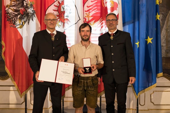 
Matthias Wallnöfer (Mitte) aus Mals rettete einen Mann aus einem rauchenden, rollenden Fahrzeug. Die Landeshauptleute Anton Mattle (links) und Arno Kompatscher ehrten ihn dafür. (Foto: Land Tirol/Sedlak)
