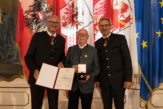 Insignito della croce al merito del Land Tirol dai presidenti provinciali Anton Mattle (a sinistra) e Arno Kompatscher (a destra): Georg Simeoni (al centro) di Egna. (Foto: Land Tirol/Sedlak)
